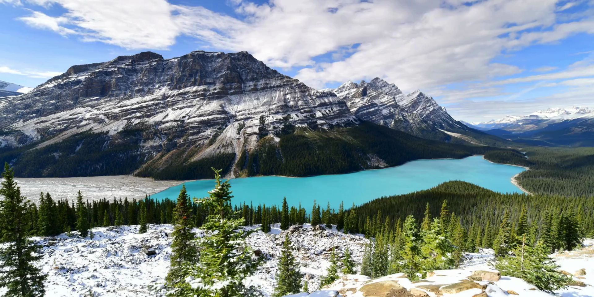 A calm turquoise mountain lake in the Alberta Rockies